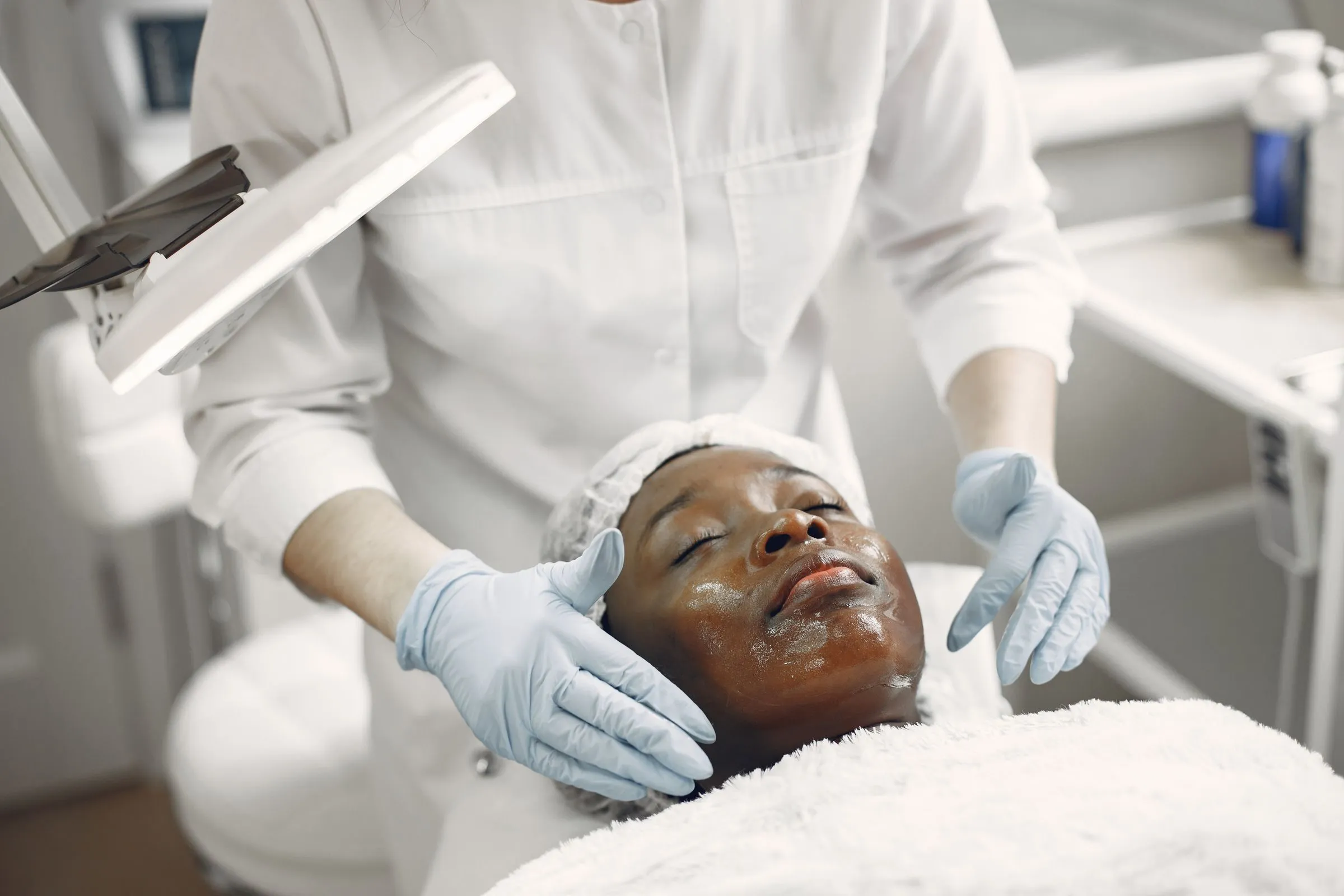 Client relaxing during a facial in a modern skin clinic
